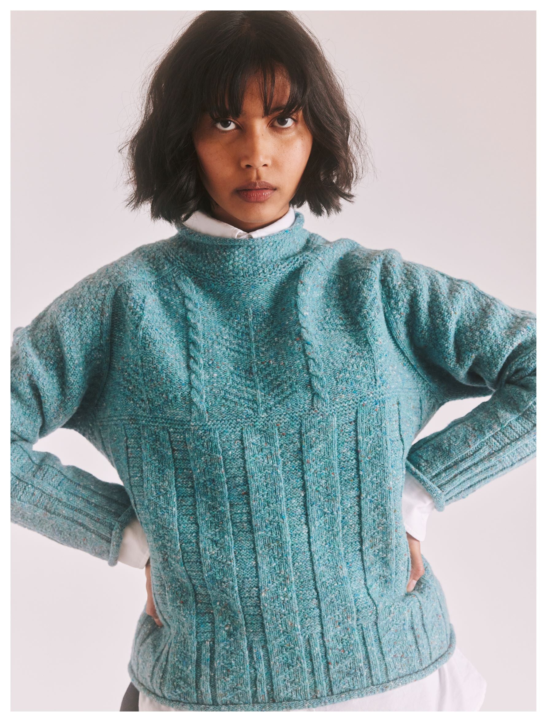 Teal speckled cable knit sweater with a mock neck.