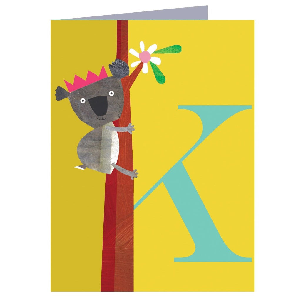 Greeting card featuring a koala wearing a crown, climbing a tree next to a large teal letter K on a yellow background.