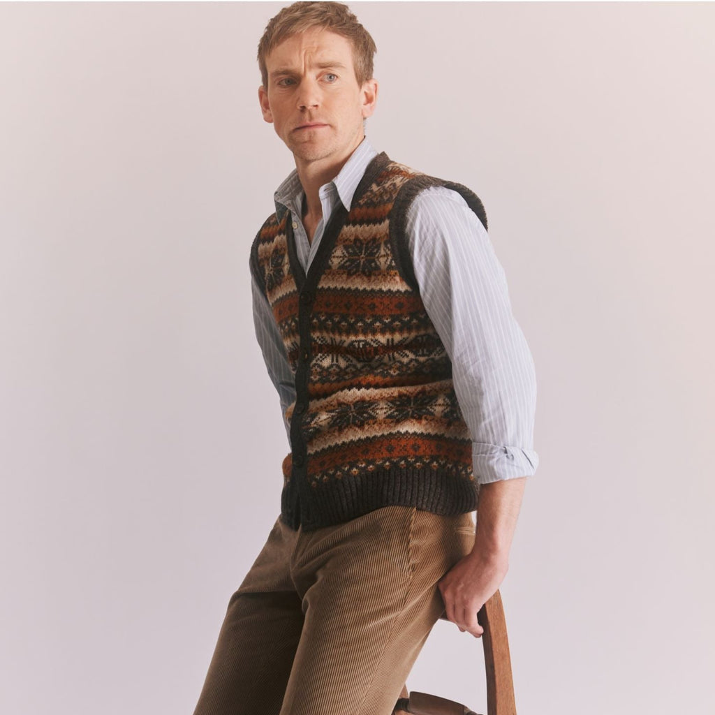 Man leaning against a chair back wearing a Harley of Scotland Men's Slipover in Elephant colourway