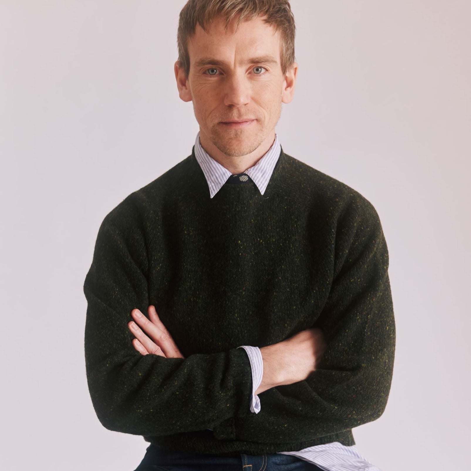 man with folded arms wearing a Harley of Scotland Men's Flecked Jumper in Harris colourway