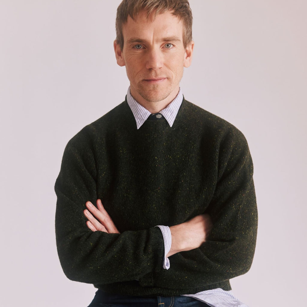 man with folded arms wearing a Harley of Scotland Men's Flecked Jumper in Harris colourway