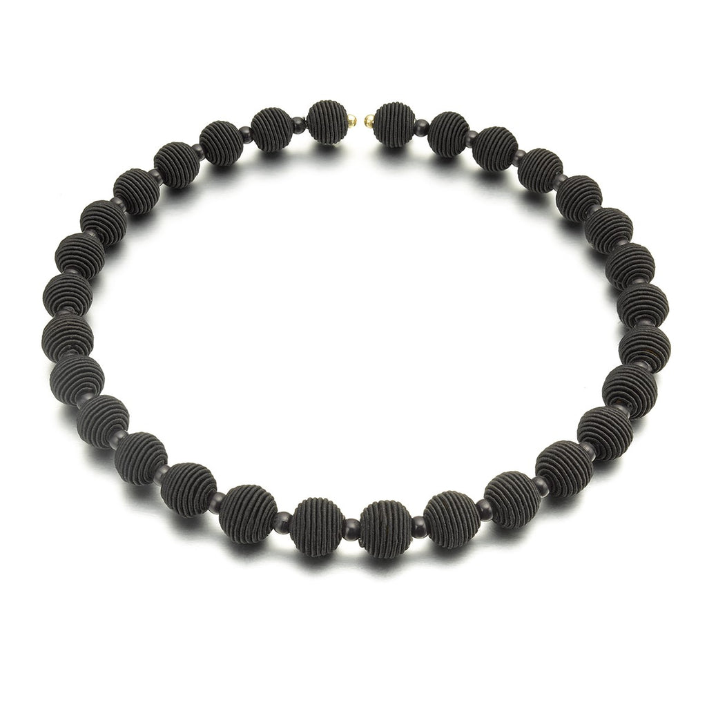 Black beaded necklace with textured, round beads.
