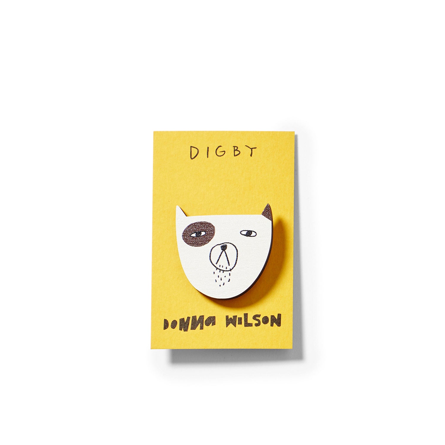 A yellow card features a cartoon dog head brooch in white and brown, branded by Donna Wilson with the name "Digby."