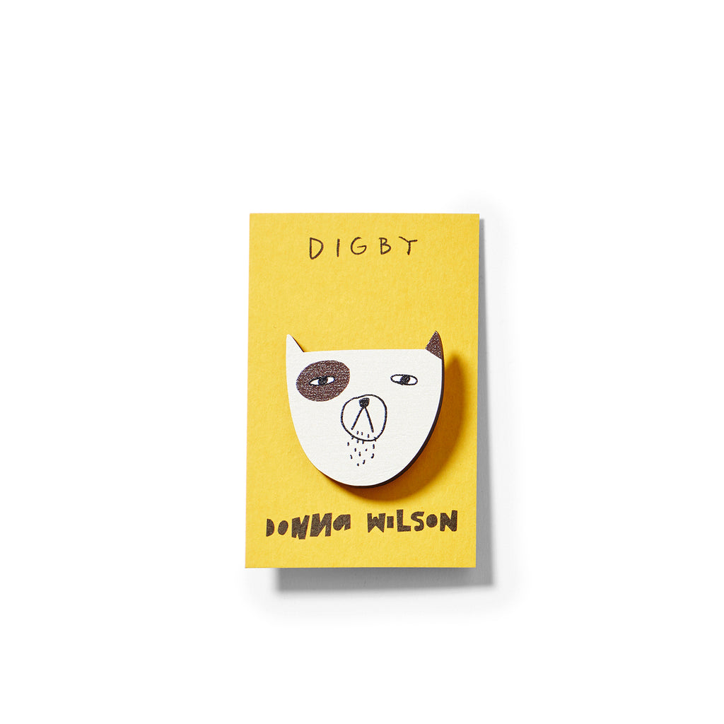 A yellow card features a cartoon dog head brooch in white and brown, branded by Donna Wilson with the name "Digby."