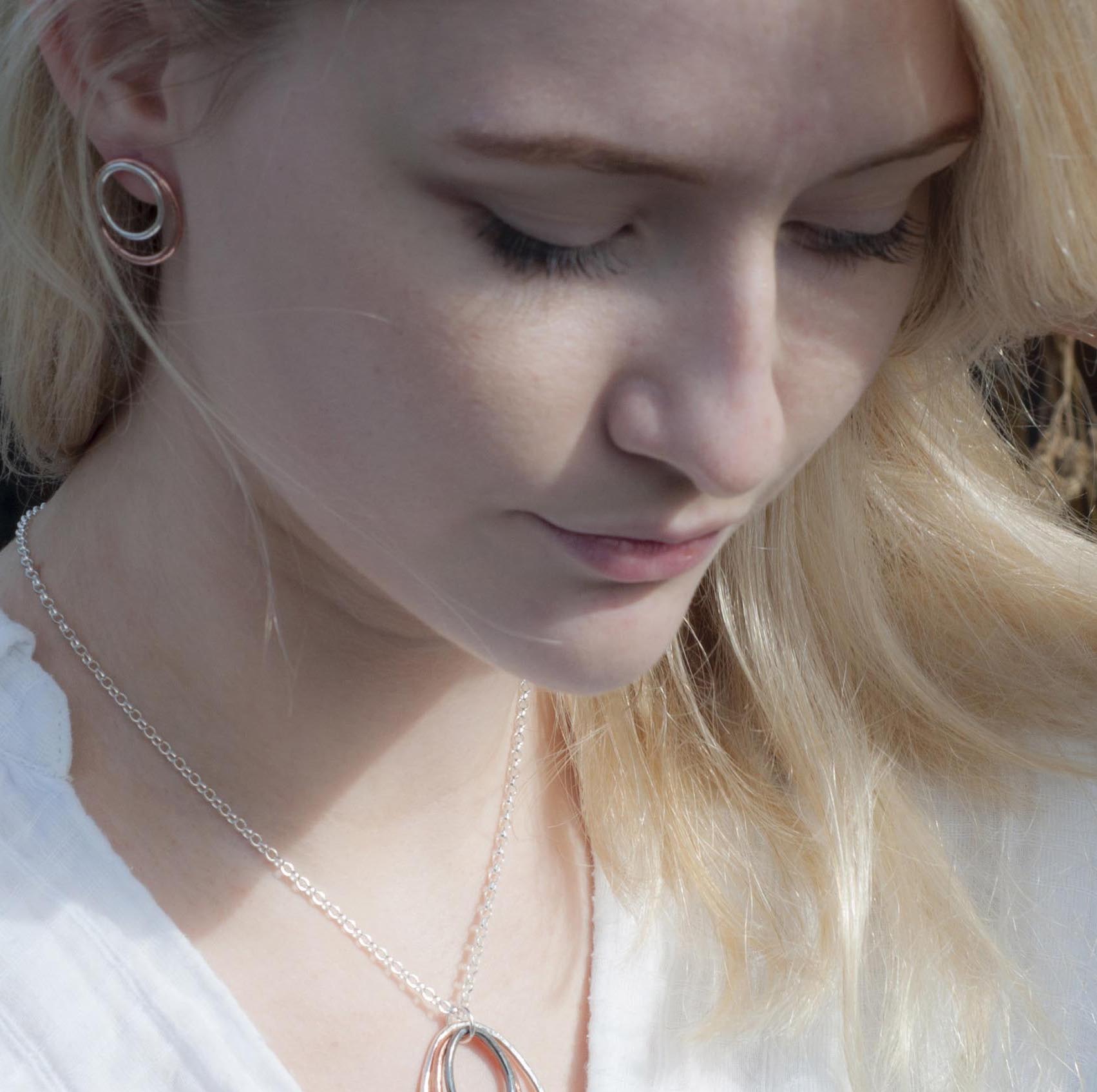 Rose gold and silver double circle earrings and a silver chain necklace with a mixed metal pendant.