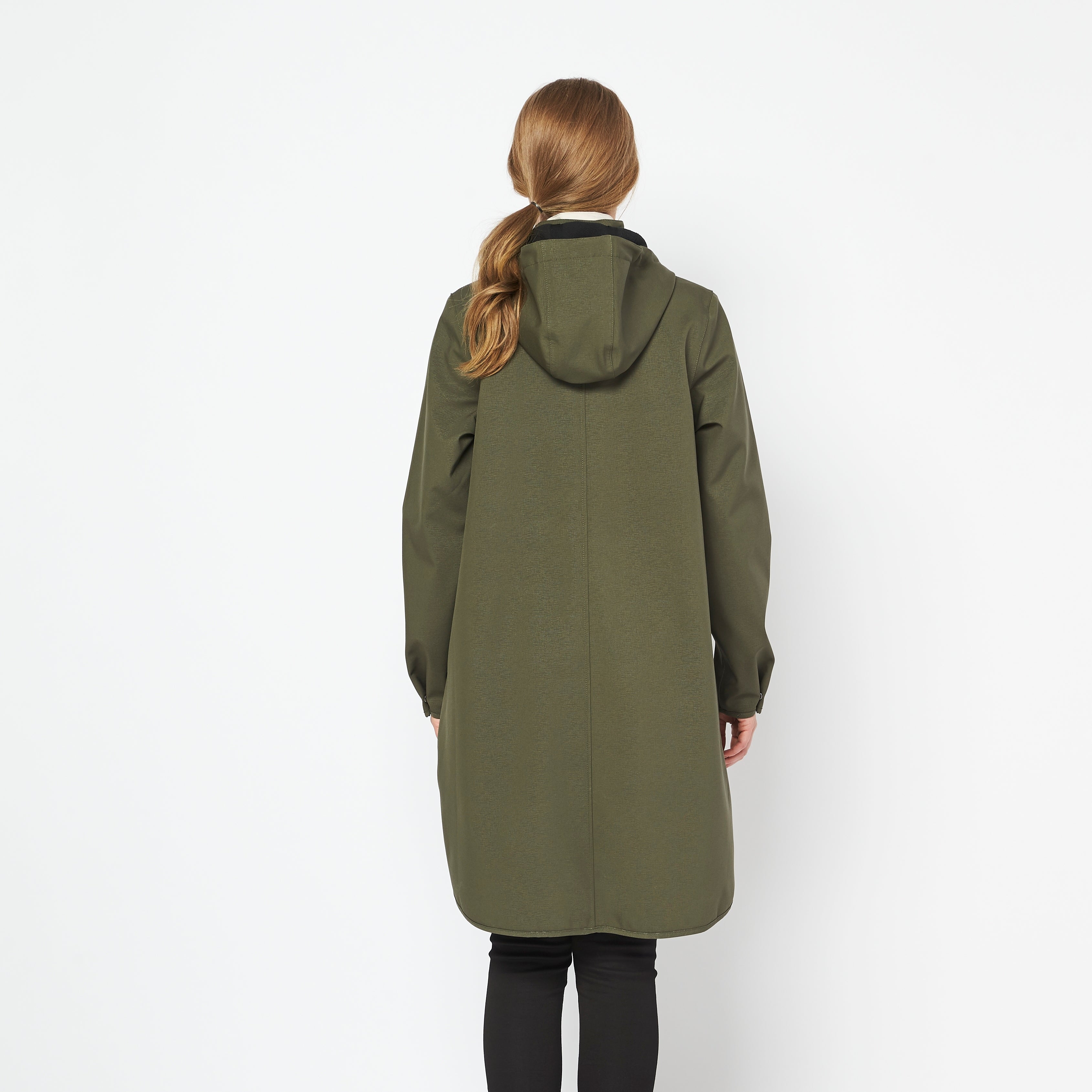 Rear view of olive green hooded long coat, featuring a subtle textured fabric. The model's light brown hair is in a ponytail.