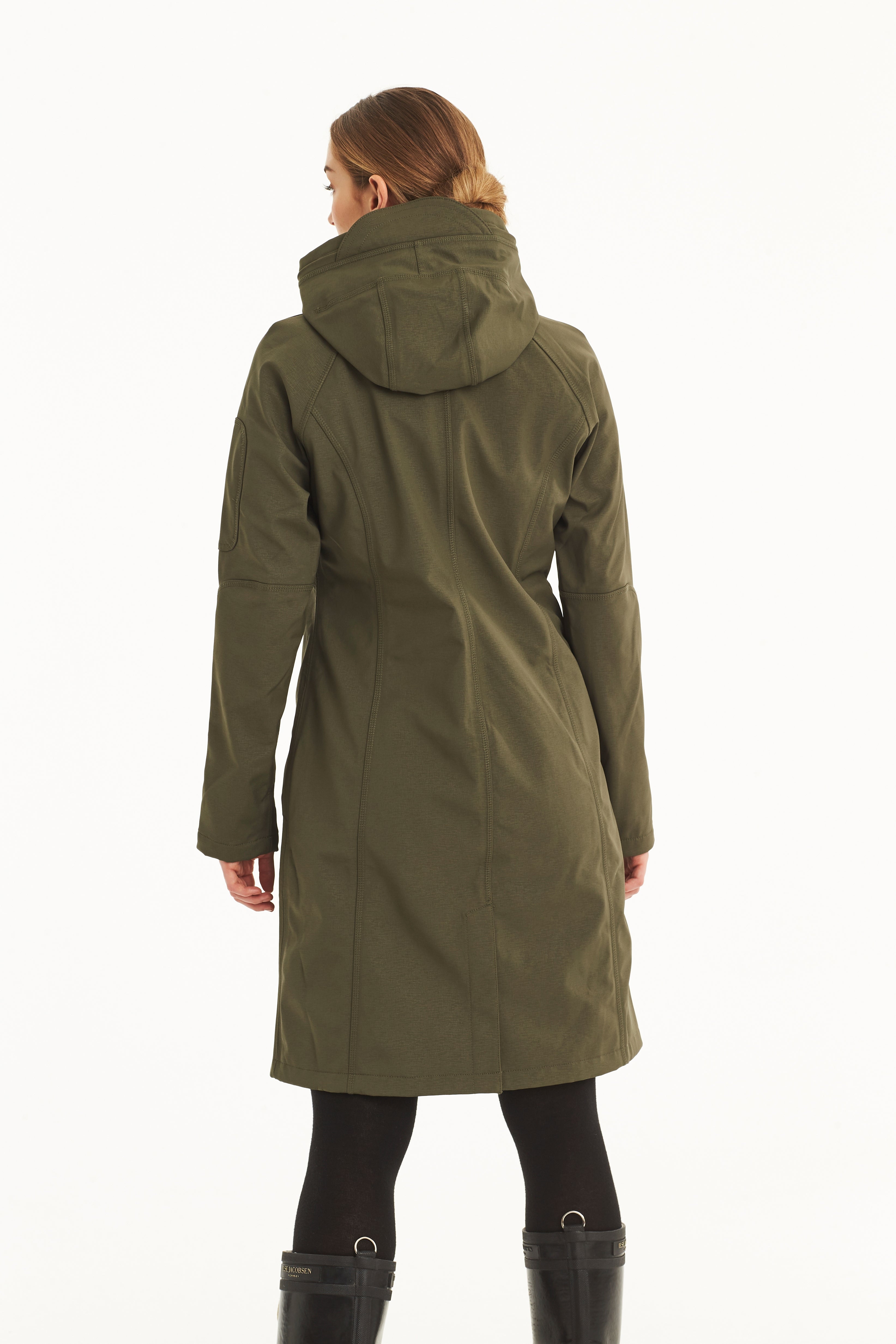 Rear view of a woman wearing a long olive-green softshell hooded coat with subtle stitching detail. The coat is knee-length and