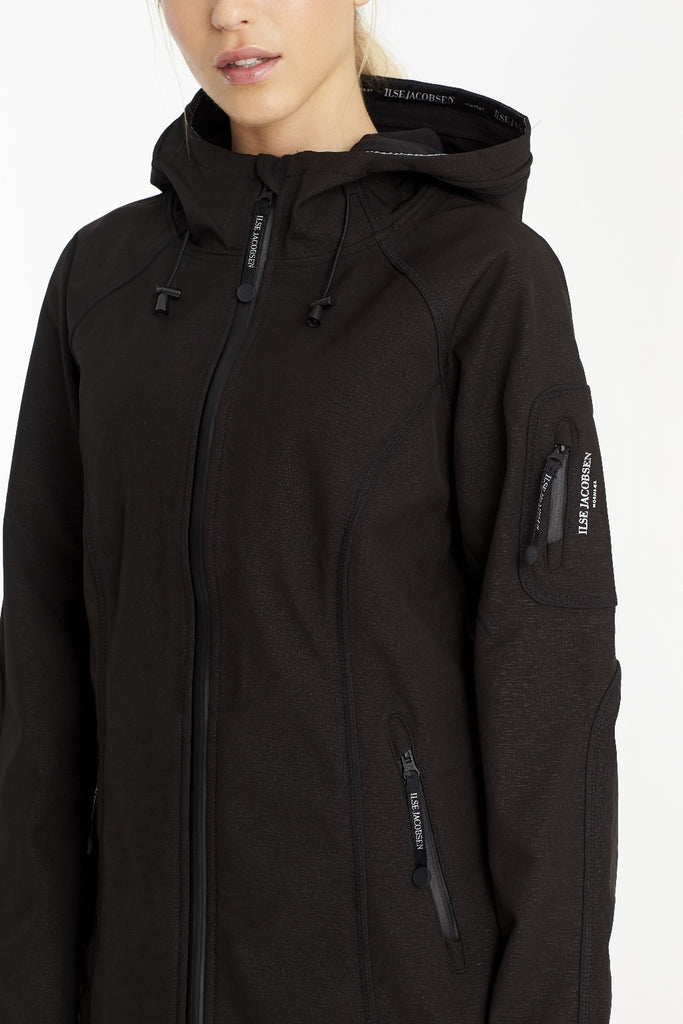 Black Ilse Jacobsen hooded softshell jacket with subtle texture, zippered pockets, and brand logo details.