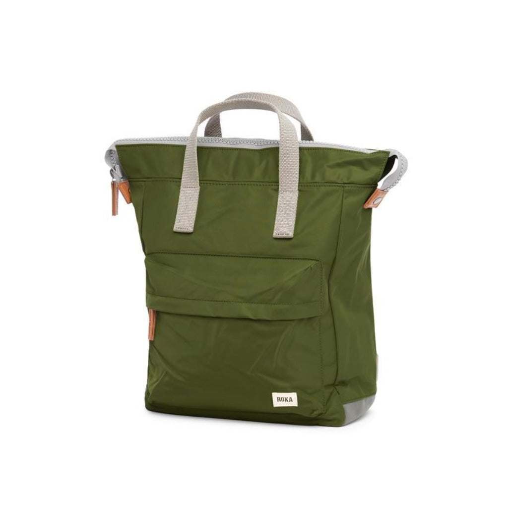 Olive green Roka backpack with light grey handles and tan leather accents. Features a flap top closure and front pocket.
