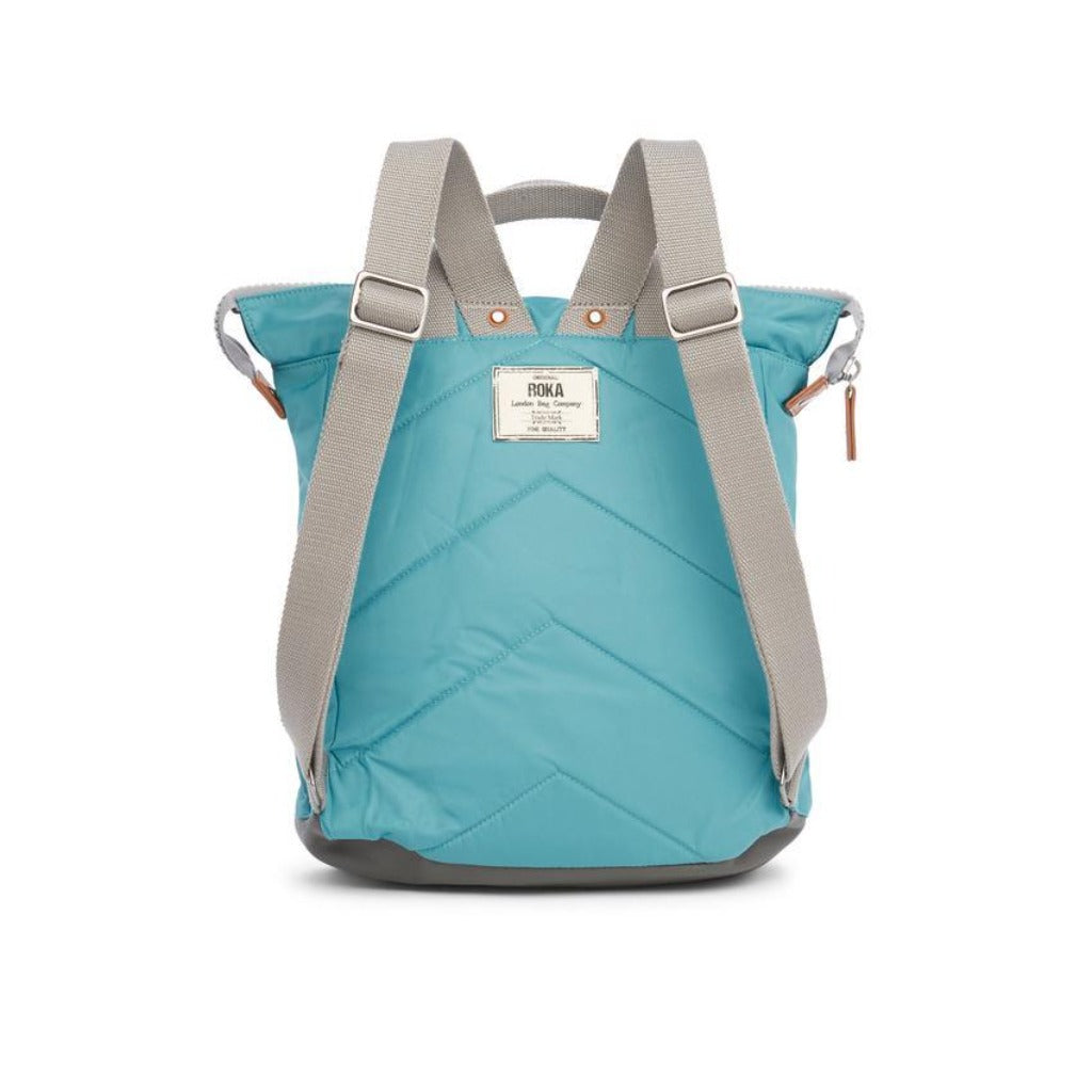 Teal quilted backpack with gray straps and handles. Features a small brand label.
