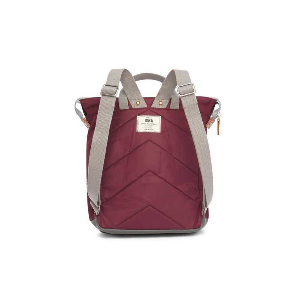 Burgundy quilted backpack with gray straps and accents. Features a top handle and chevron-patterned design.