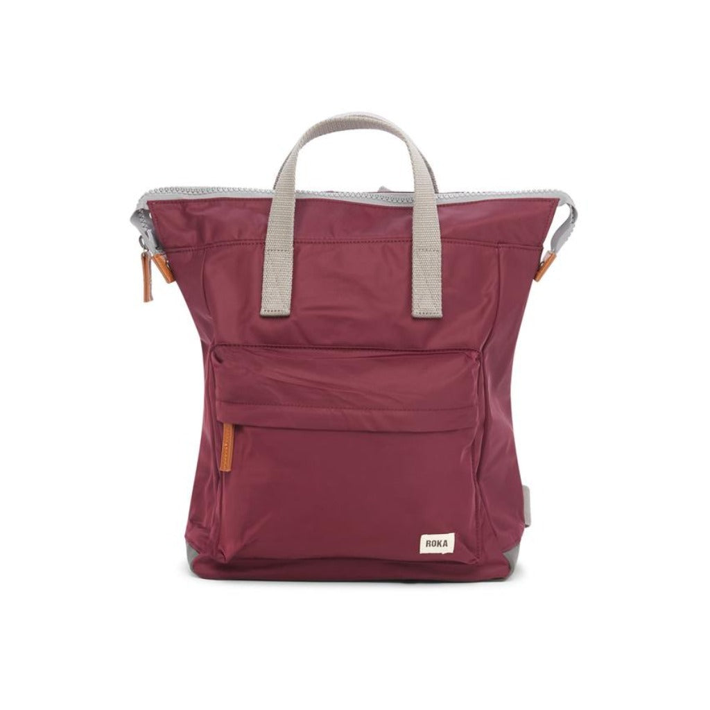 Burgundy RoKa backpack with light grey top handles and accents. Features a front zippered pocket and a small brand label.