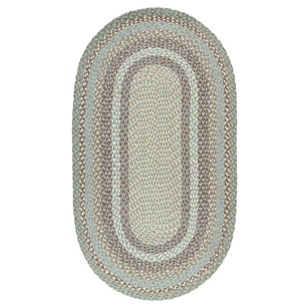 Oval braided rug in shades of green, beige, and brown. The rug features a multi-striped border surrounding a lighter center.