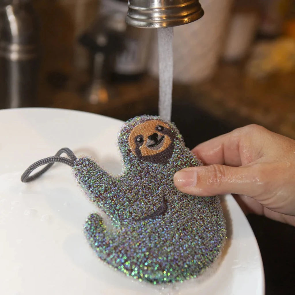 Glittery sloth-shaped sponge being rinsed.