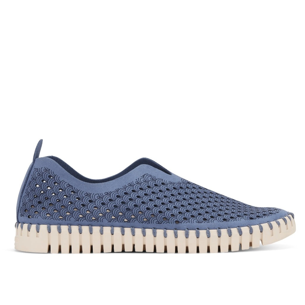 Dusty blue slip-on shoe with a textured, perforated upper and cream-colored scalloped sole.