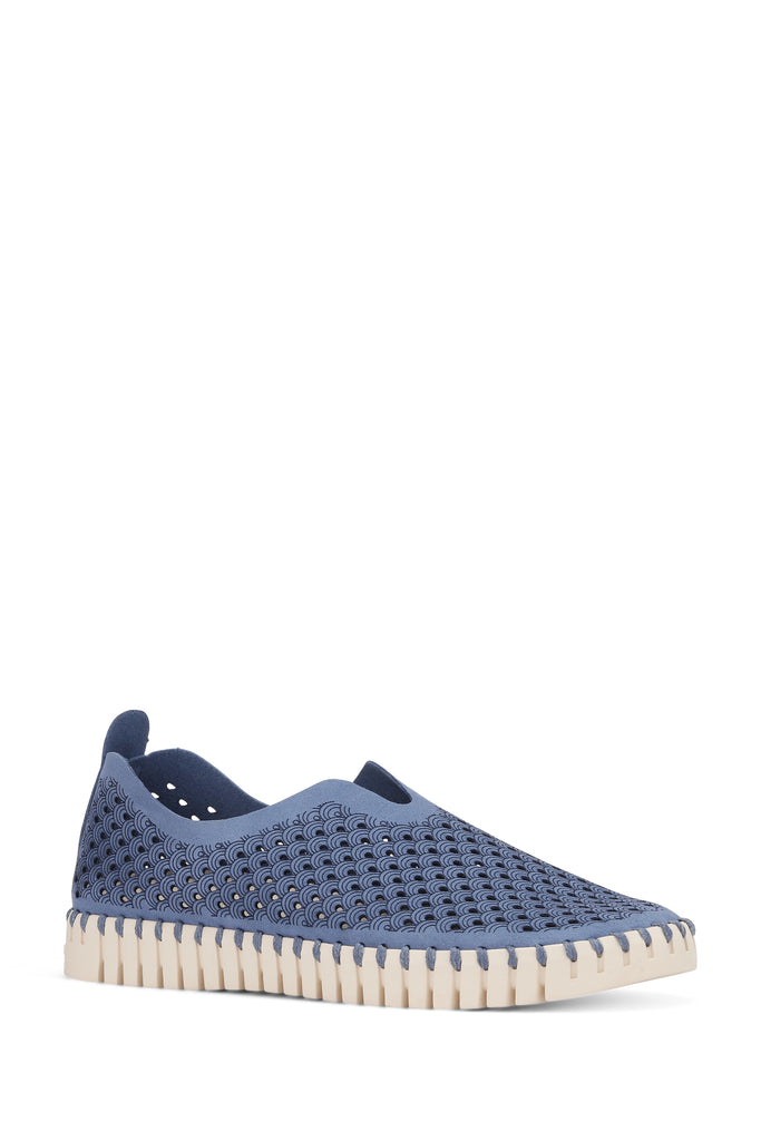 Dusty blue slip-on shoe with off-white scalloped sole and repeating wave pattern perforations.