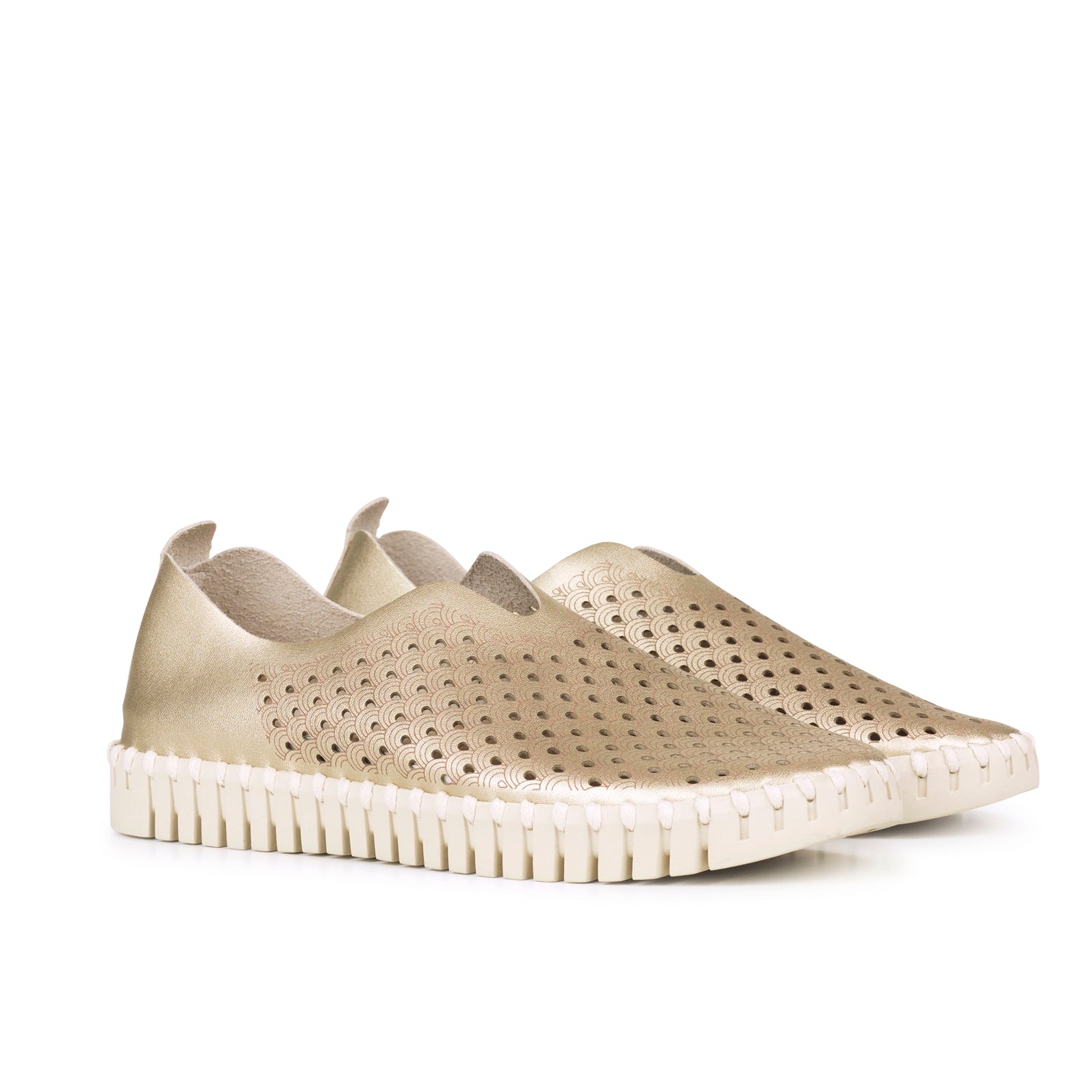 Pair of gold leather slip-on shoes with a textured, patterned upper and a cream-colored, ridged sole.