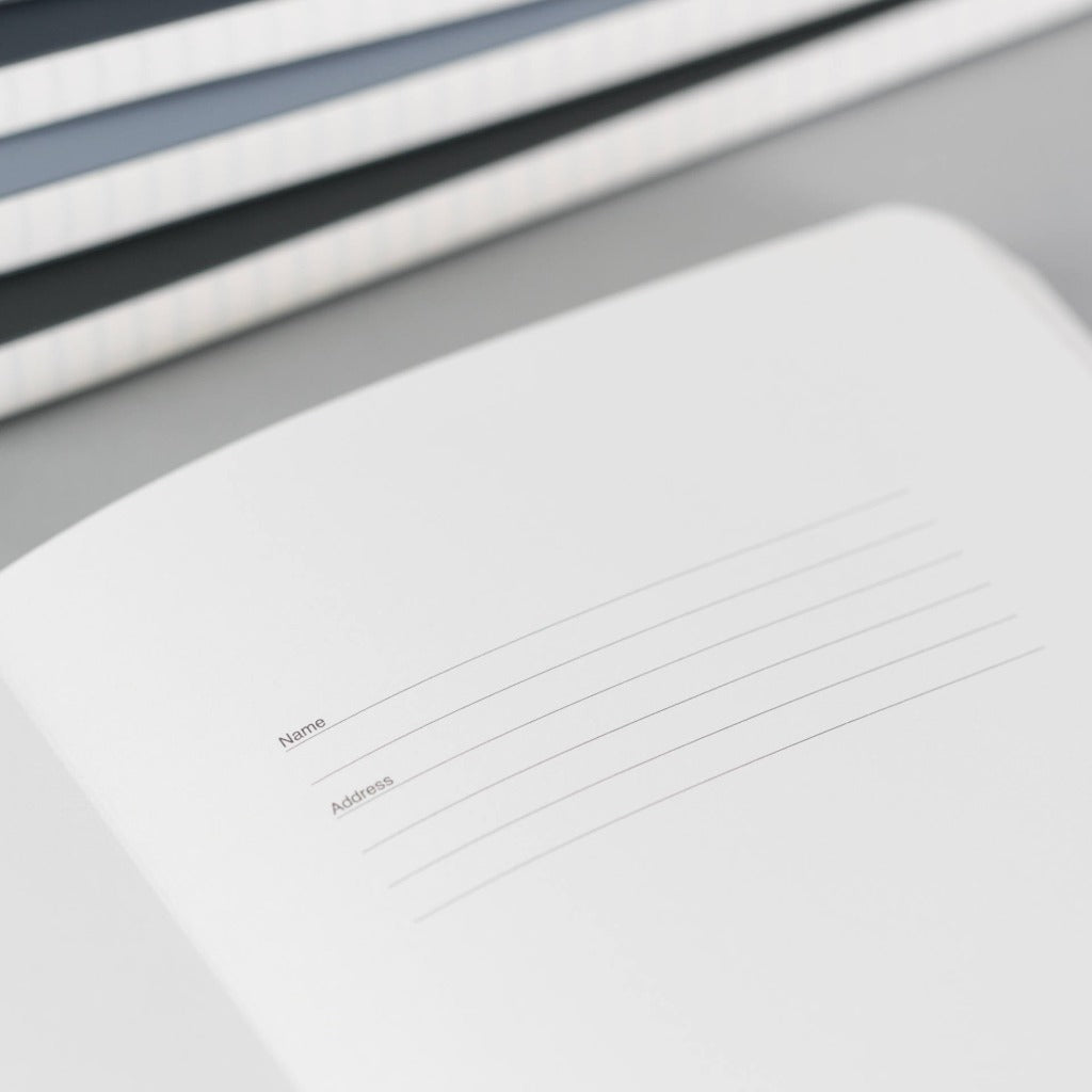 Open notebook with blank pages showing lines for name and address.
