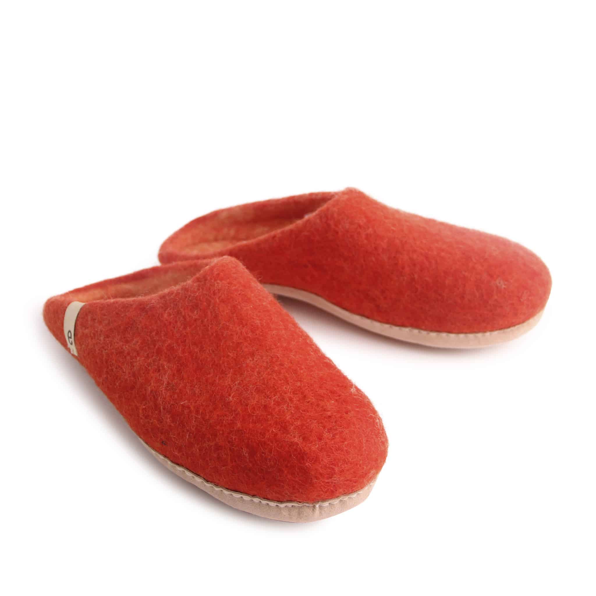 Pair of orange felt slippers with a light tan sole.