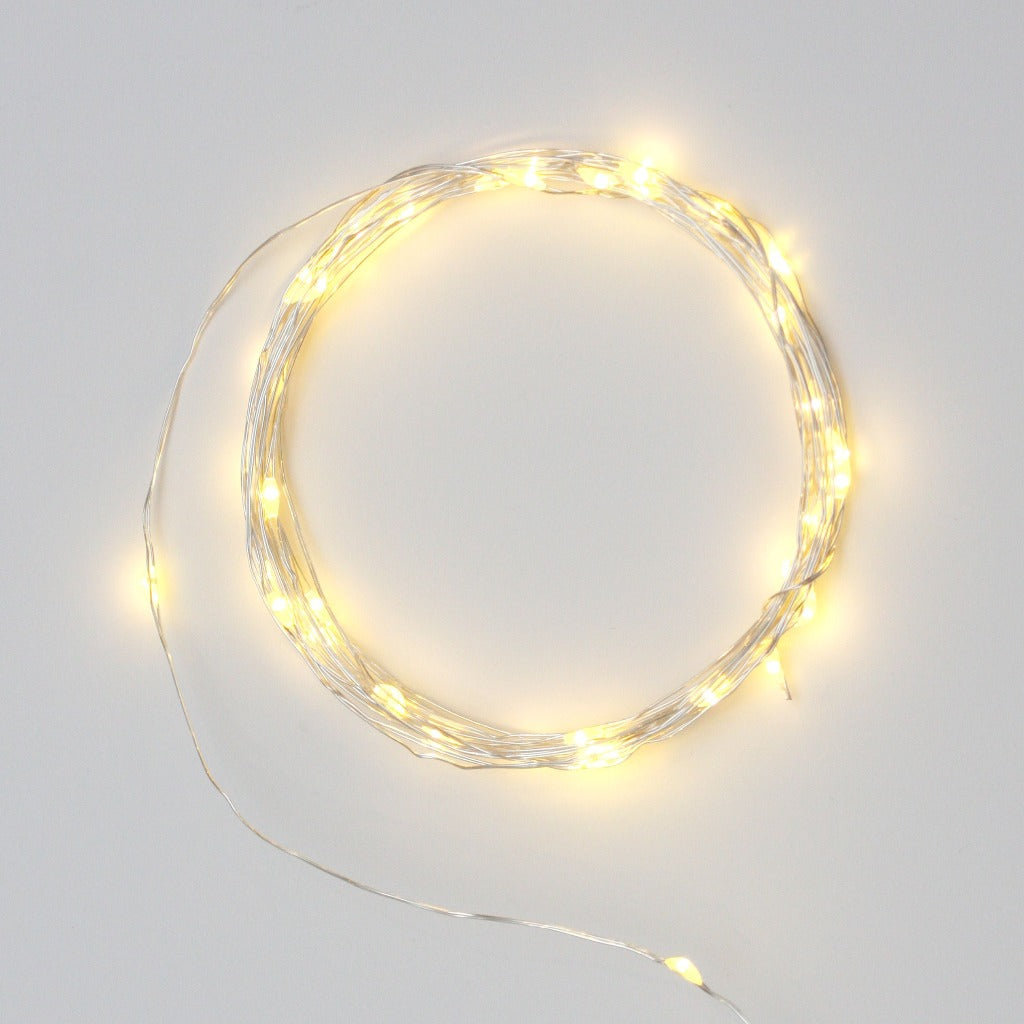Silver wire string lights arranged in a circle, emitting warm white light.