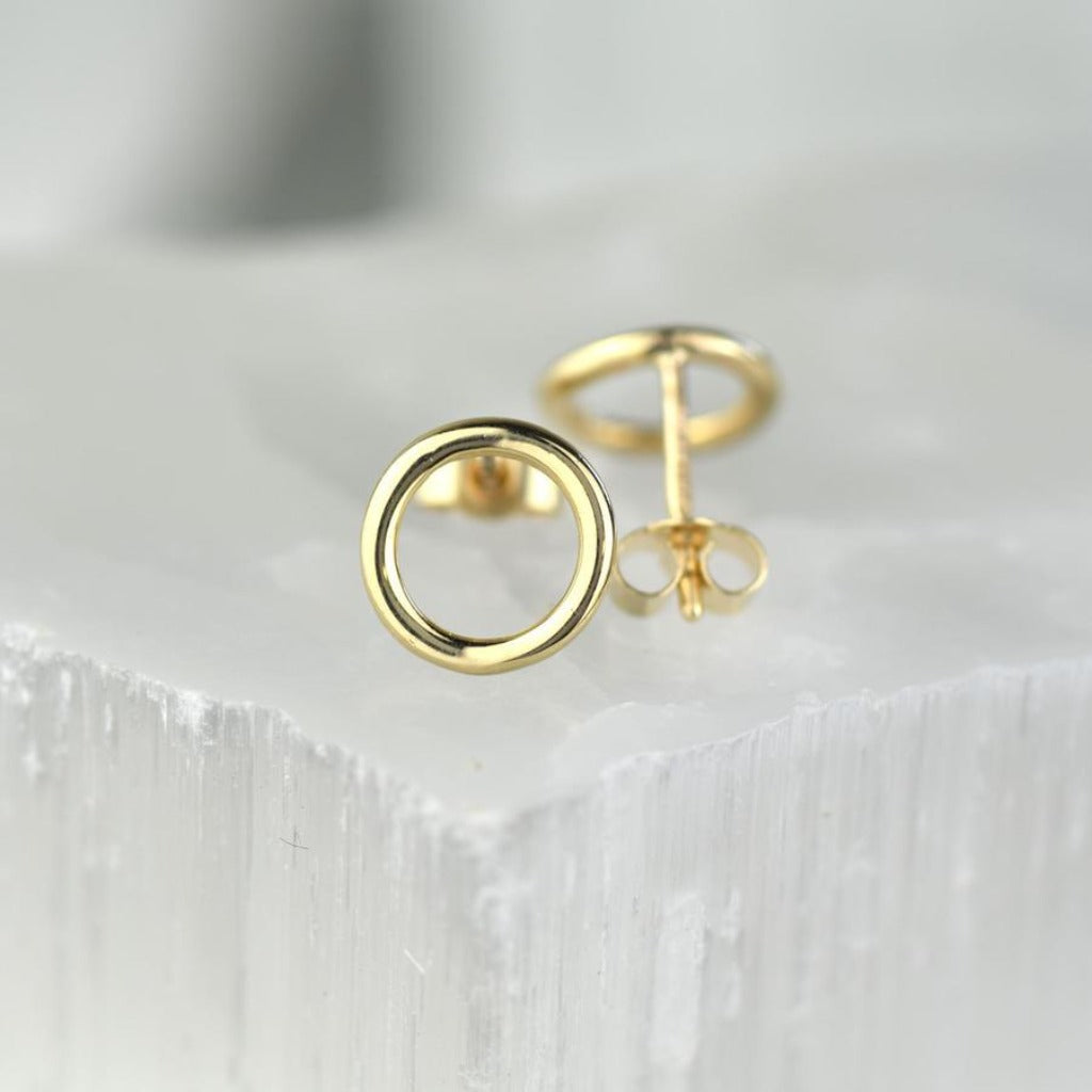 Pair of gold circle stud earrings.  Simple, minimalist design.