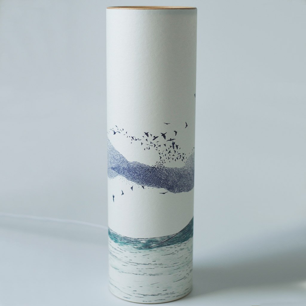 Tall cylindrical container with off-white background and a design featuring a flock of birds flying over a stylized seascape.
