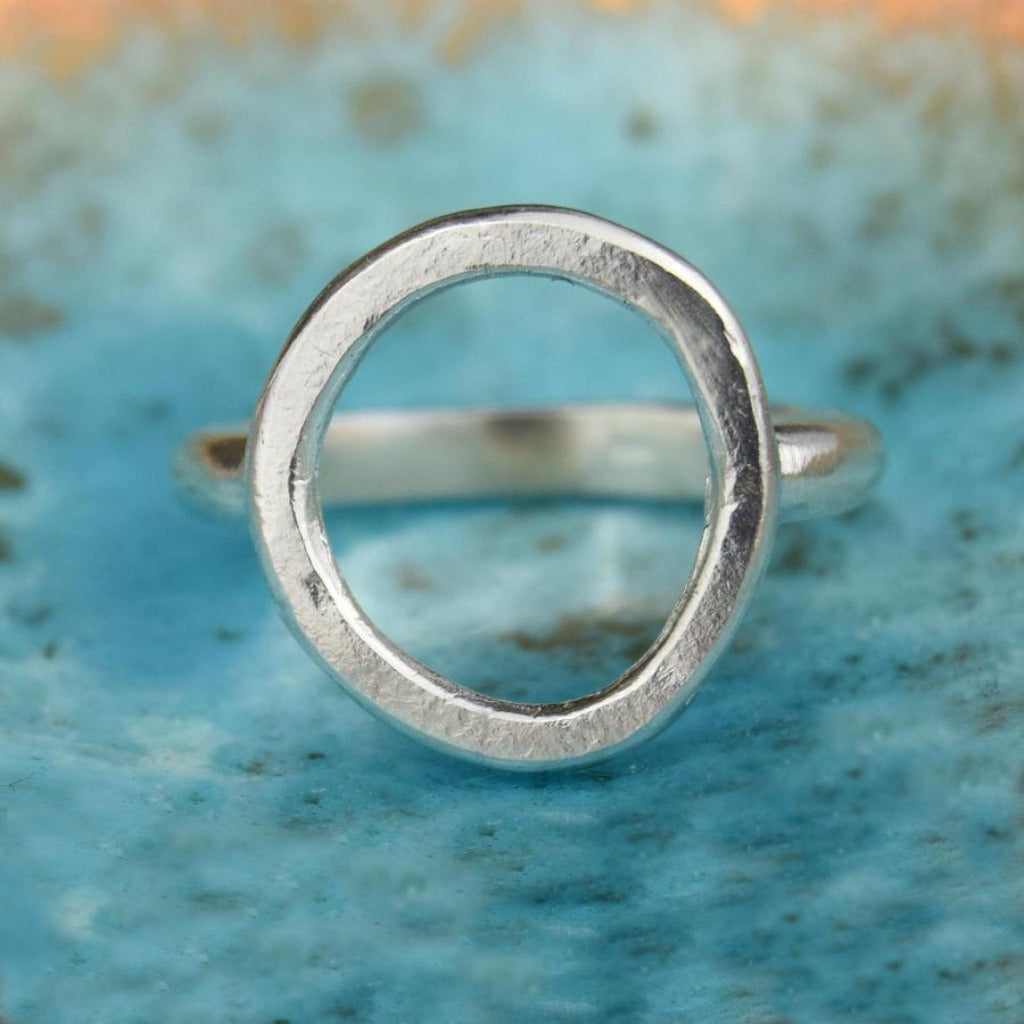 Silver ring with a textured, circular band.