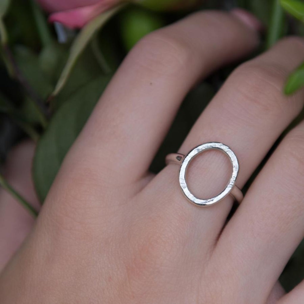 Silver ring with a textured, oval-shaped open band.