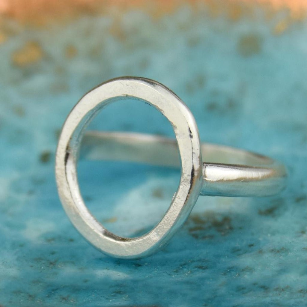 Silver ring with a large, slightly irregular circular cutout.