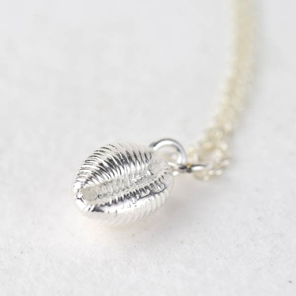 Silver necklace featuring a detailed seashell pendant.