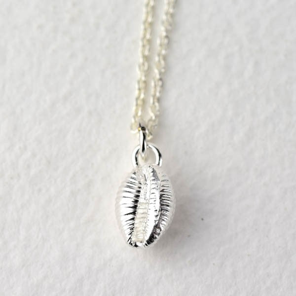 Silver necklace with a detailed shell pendant.