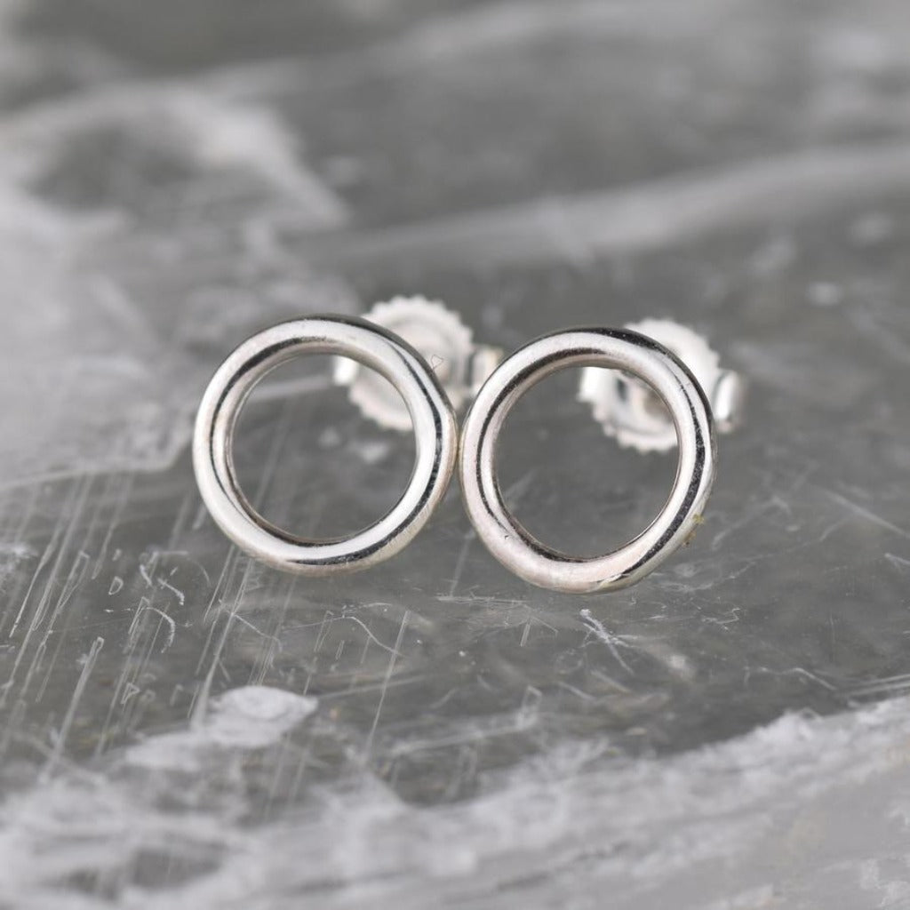 Pair of silver circle stud earrings.  Simple, minimalist design with smooth, rounded edges.