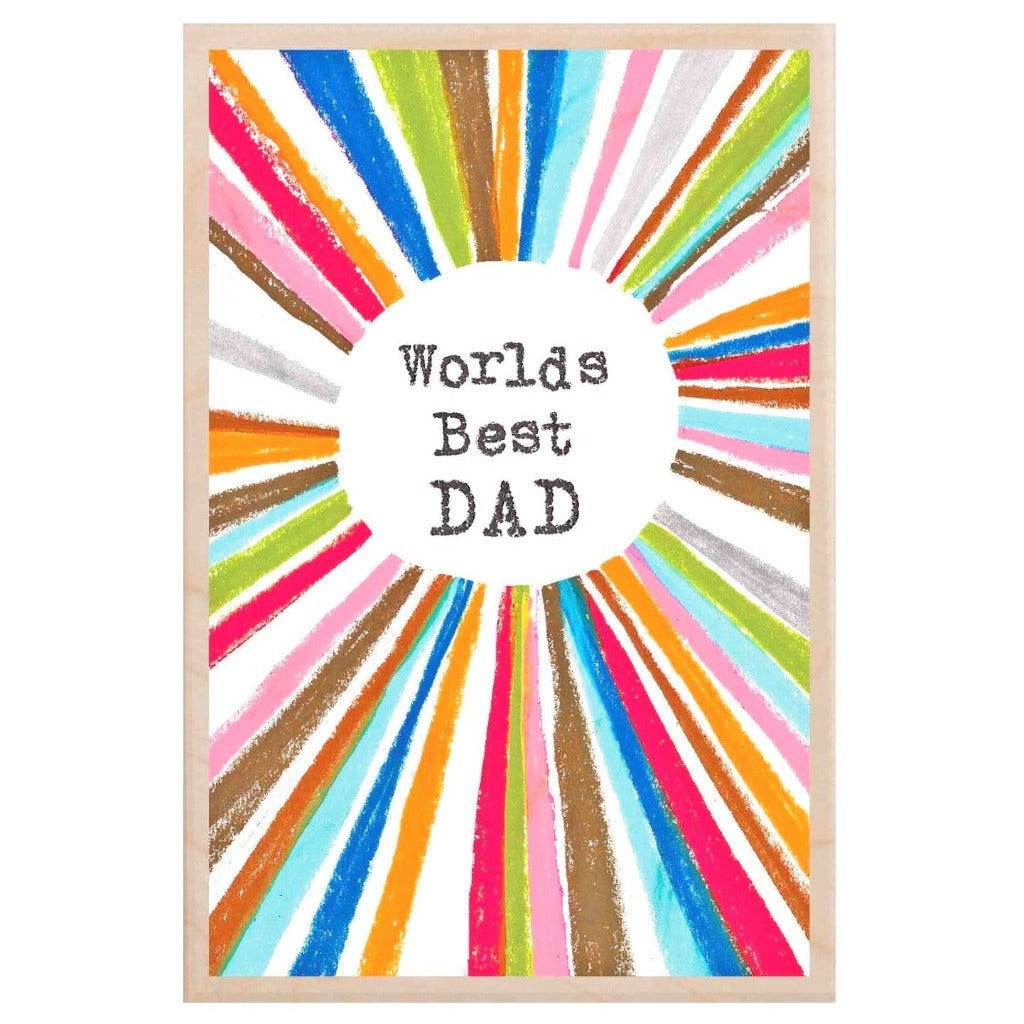 "World's Best Dad" in a circle surrounded by colorful radiating lines on a wood block print.